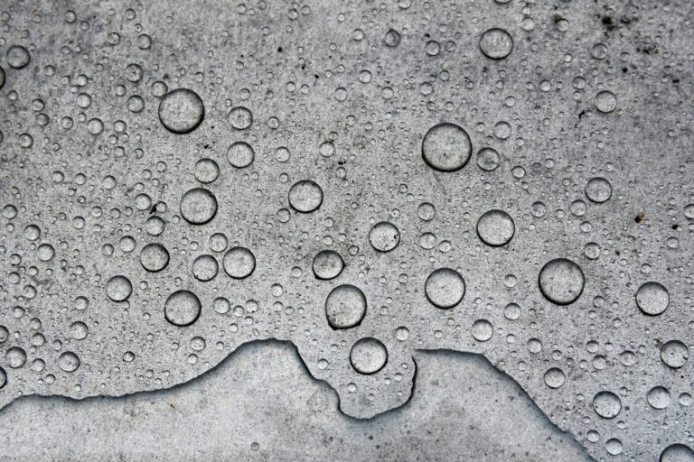 Thin film of condensation on a bare concrete basement floor